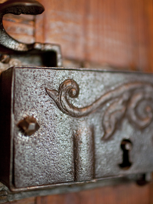 Nahaufnahme eines verschnörkelten alten Metalltürschlosses mit dekorativem Wirbelmuster und sichtbarem Schlüsselloch.